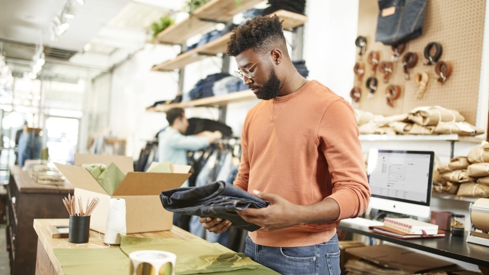 contemporary denim brand store owner packing order for pick up