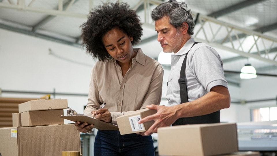 Warehouse colleagues preparing packages for shipping