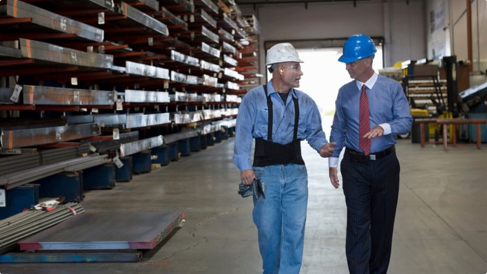 Warehouse worker and businessman in hard hats