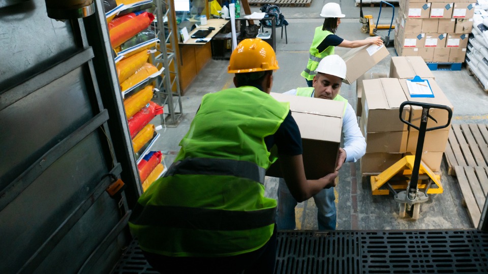 group of workers loading a truck with boxes at a distribution warehouse