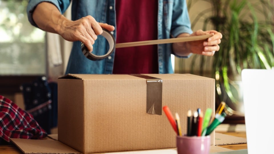 Man returning an item and sealing the package with duct tape