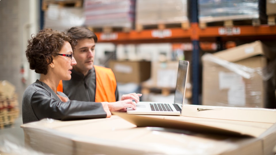 Fulfillment center workers manifesting shipments using UPS software