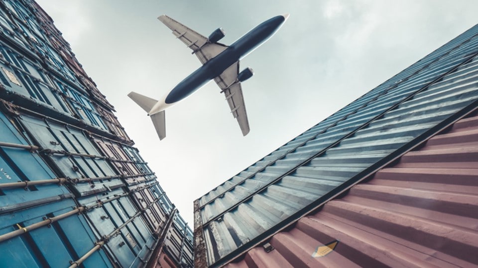 Plane flying over a container yard